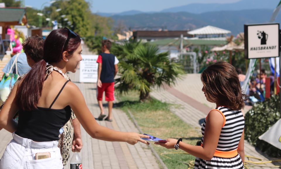 A young woman handling a leaflet to another woman