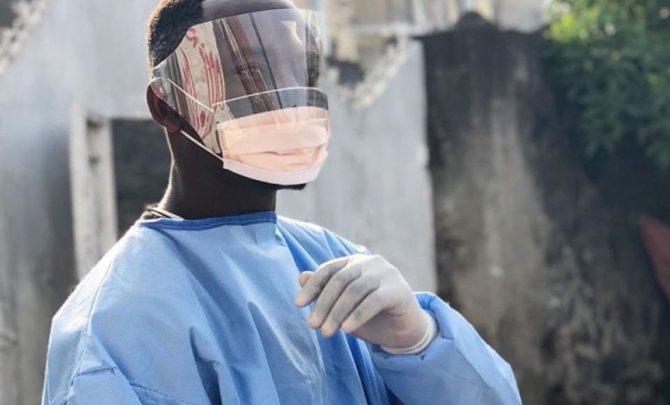 a medical professional wearing protective clothing looking at the camera
